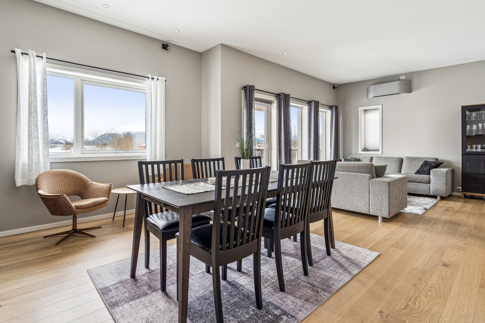 Vi kommer inn i en moderne stue med store vinduer som slipper inn godt med naturlig dagslys. Galleribilde