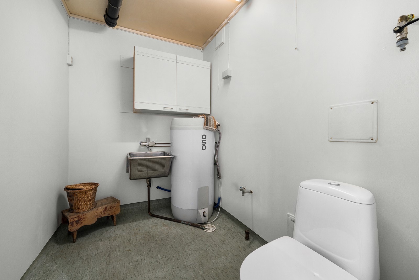 Praktisk vaskerom fra byggeår med belegg på gulv og malte flater på vegger. Av sanitærutstyr er det skyllekar i stål, opplegg for vaskemaskin og gulvstående toalett. Det er også montert varmtvannsbereder på ca. 200 liter av nyere dato ifølge selger! Galleribilde