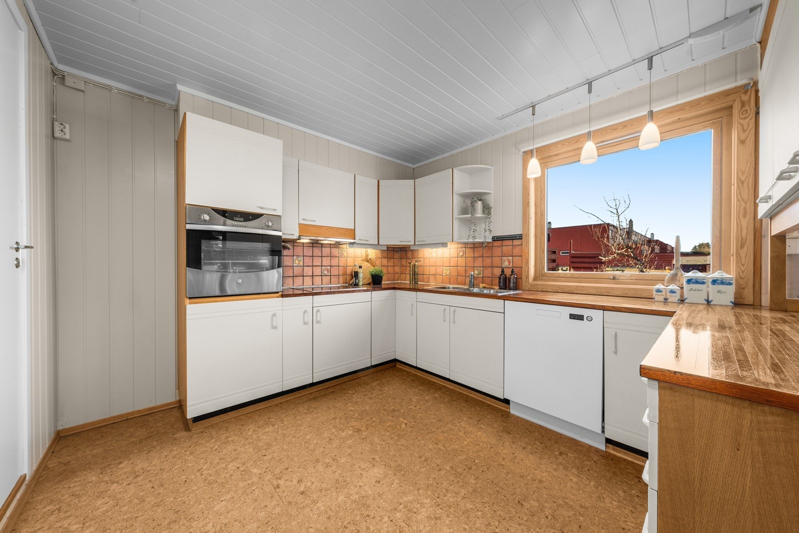 Kjøkkeninnredning med malte fronter, oljet muteyin heltre benkeplate og fliser på vegg over benk. Integrert platetopp, komfyr i fin arbeidshøyde og nedsunket dobbel oppvaskkum! Galleribilde