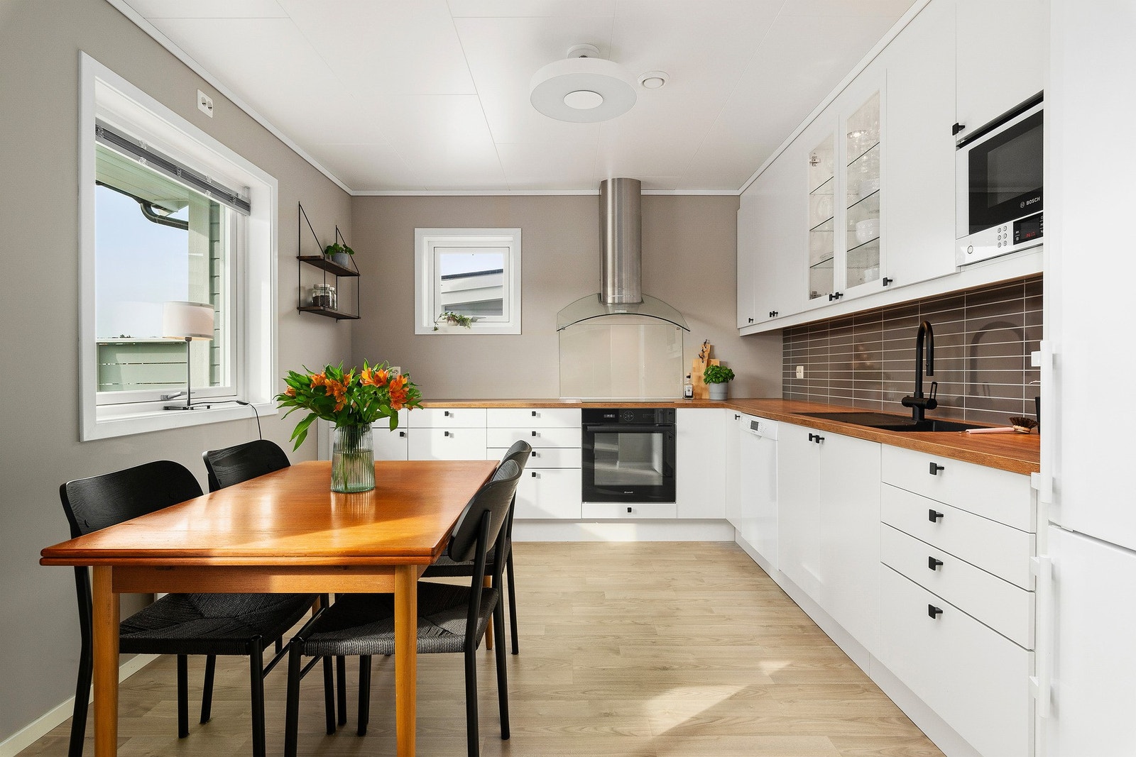 Elegant kjøkkenvifte samt plexiglass ved kokesonen. Boligen har for øvrig balansert ventilasjonsanlegg. Legg også merke til elpunkt for eventuell pendellampe. Galleribilde