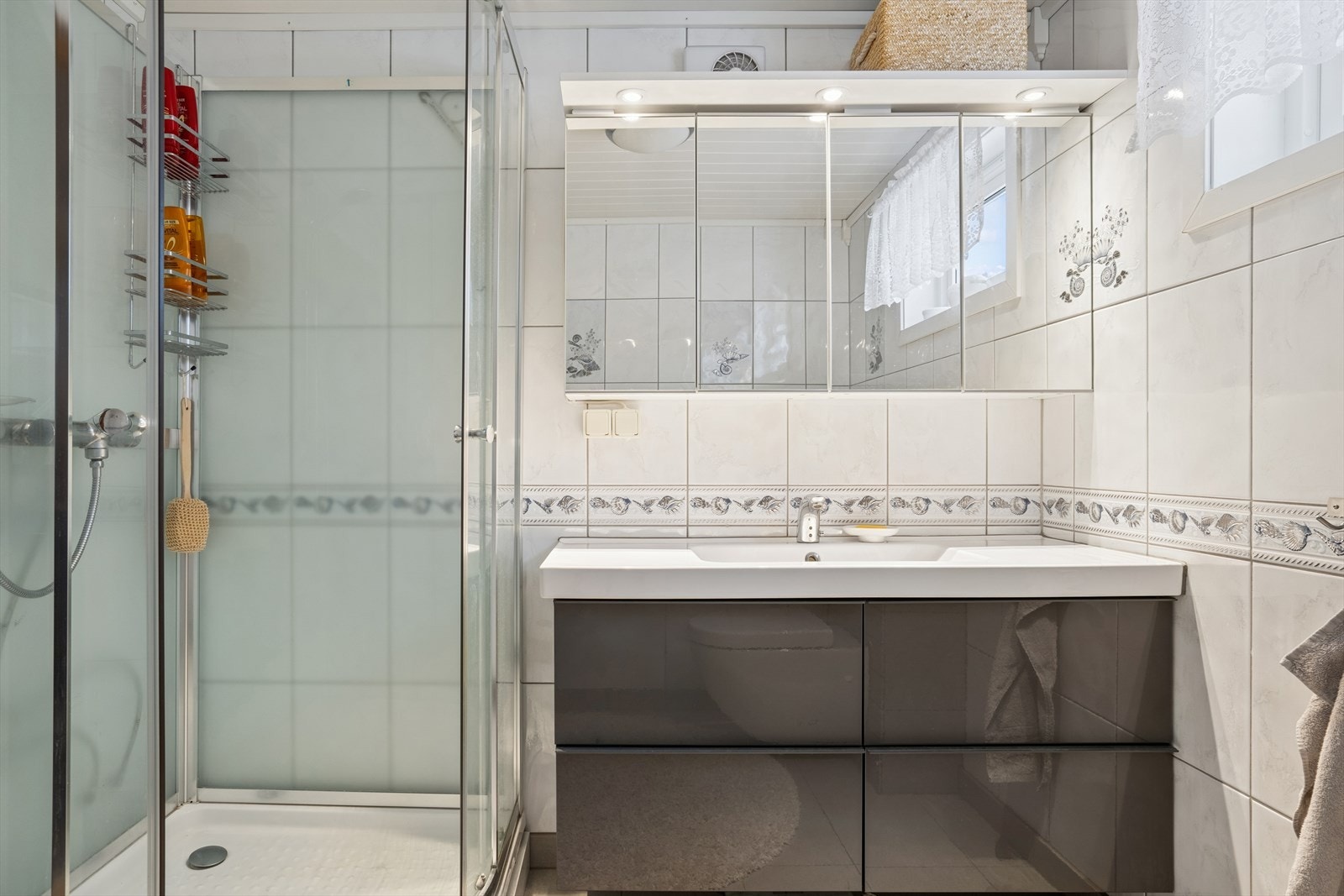 Moderne og romslig baderomsinnredning med mye oppbevarngsplass for baderomsartikler. Galleribilde