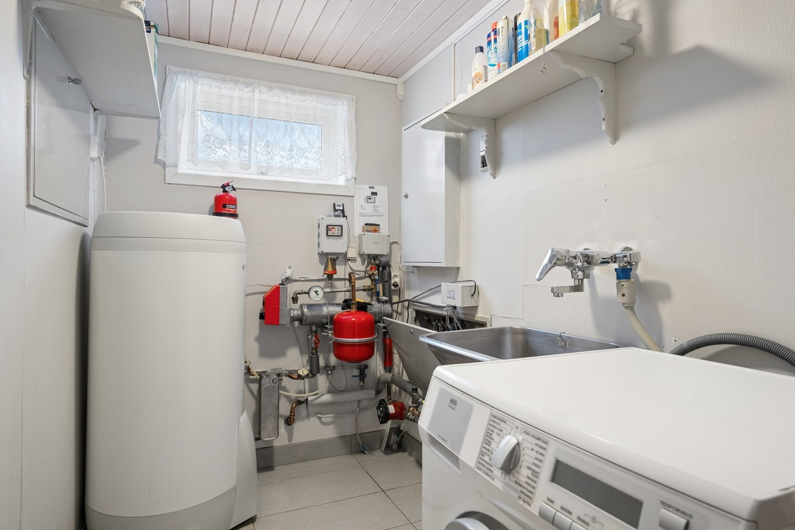 Praktisk separat vaskerom med opplegg for vaskemaskin og utslagsvask på vegg. Galleribilde