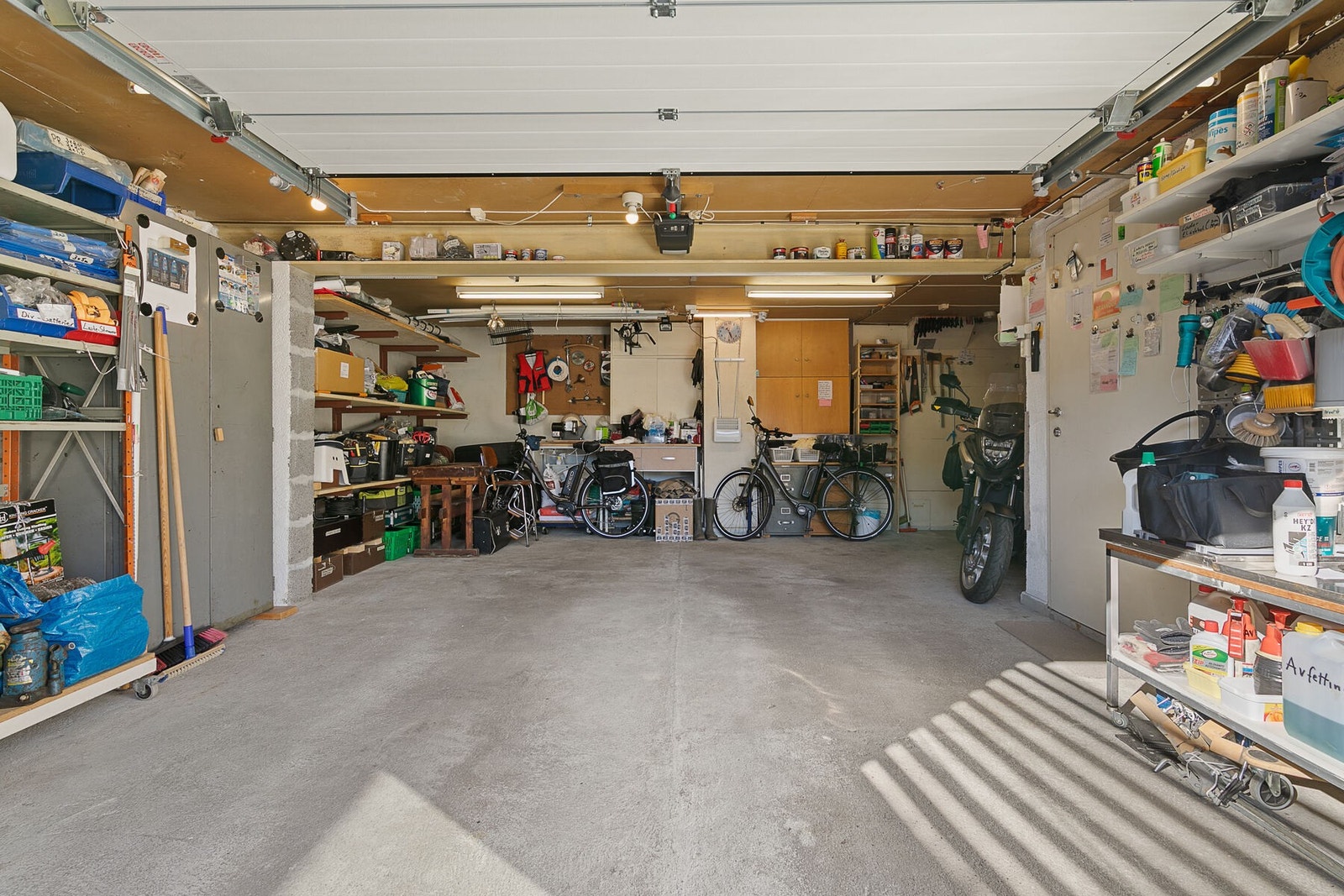 Romslig garasje med plass til arbeidsbenk, utstyrshyller og vinterdekk. Galleribilde