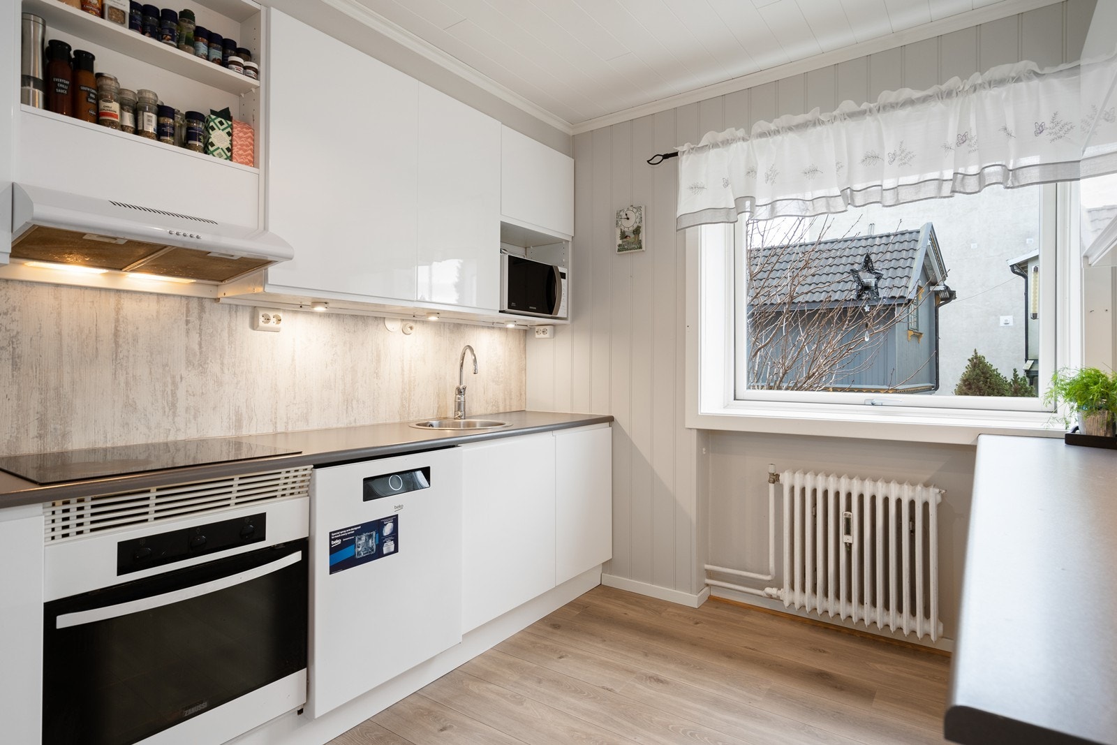 Kjøkken med både integrerte og frittstående hvitevarer Galleribilde