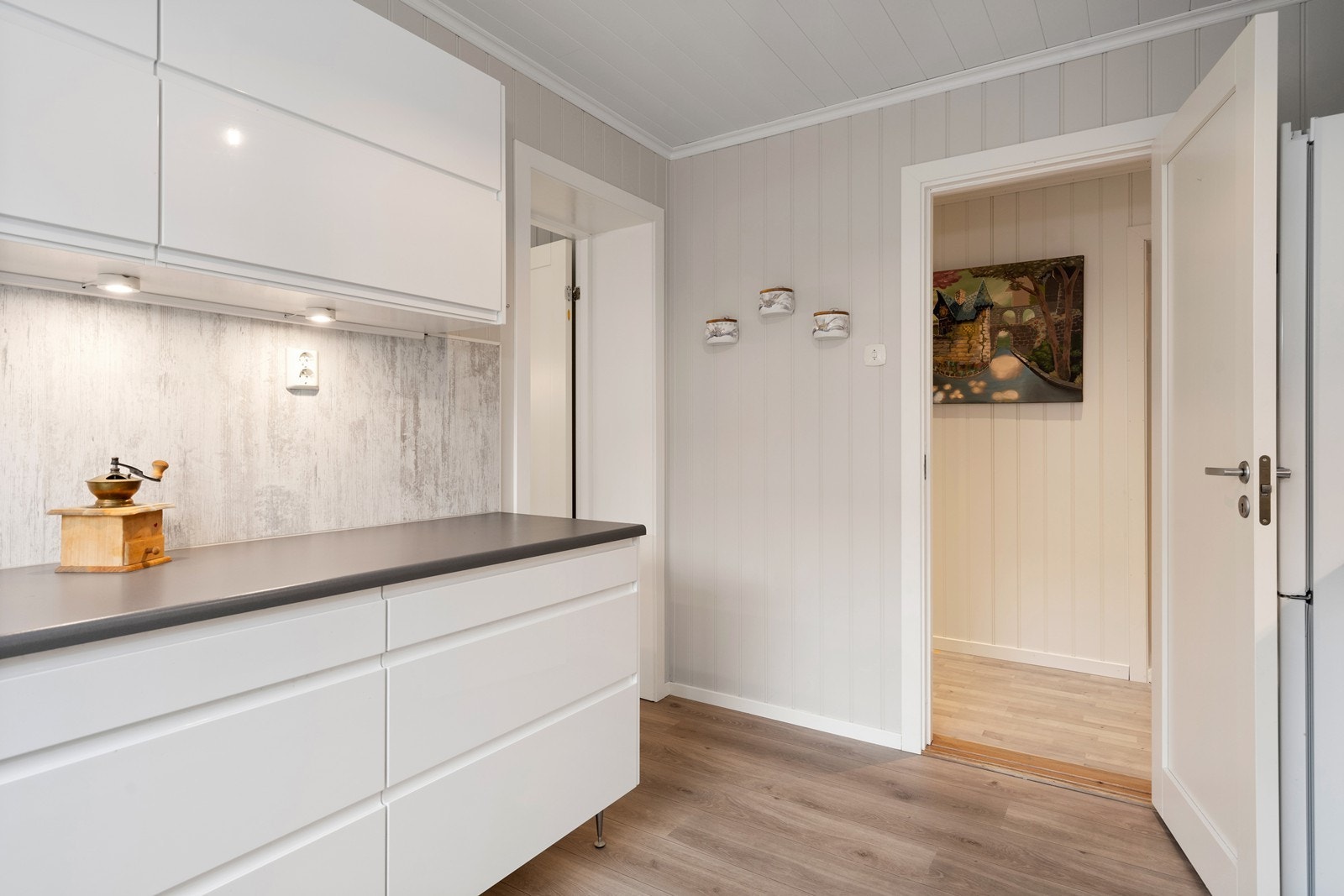 Det er downlights under overskapene på kjøkkenet, som gir et behagelig lys i rommet. Galleribilde