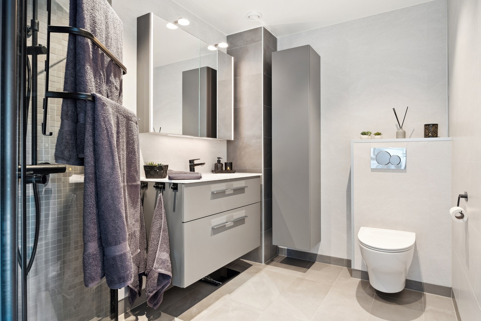 Badet er helfliset og utstyrt med gulvvarme for økt komfort. Det vegghengte toalettet gir et moderne uttrykk og bidrar til en romslig følelse. Galleribilde