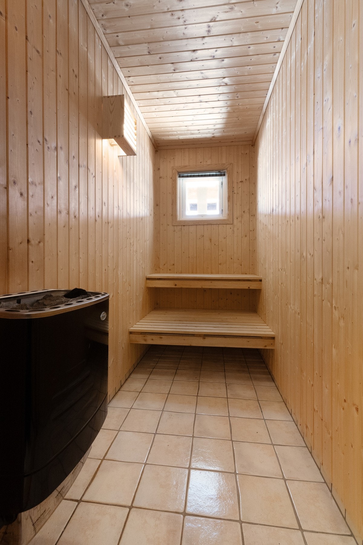 Plassbygde sittebenker i badstuen, her kan det friste å sette seg etter en lang dag ute i fjellet Galleribilde