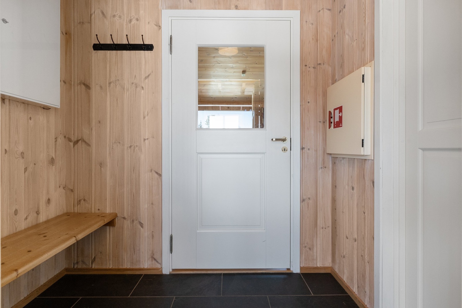 Entré med plassbygd benk samt oppheng på vegg for yttertøy Galleribilde