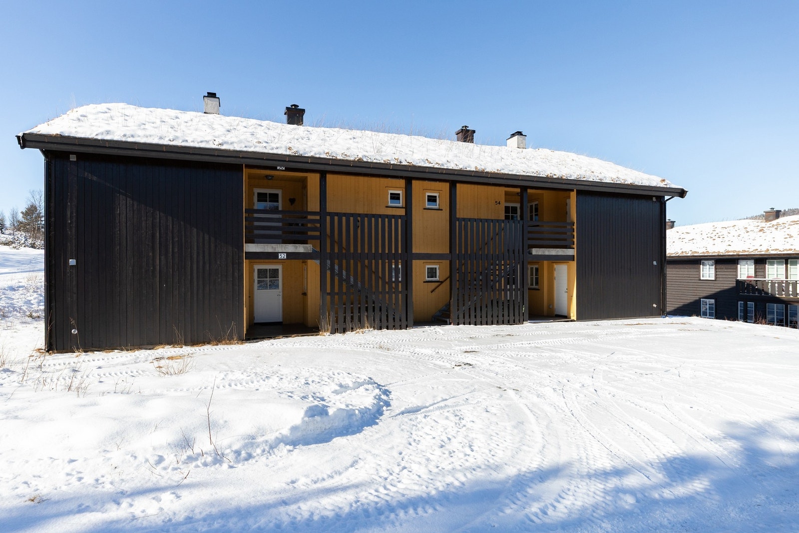 Overbygd inngangsparti med trapp opp til leiligheten Galleribilde