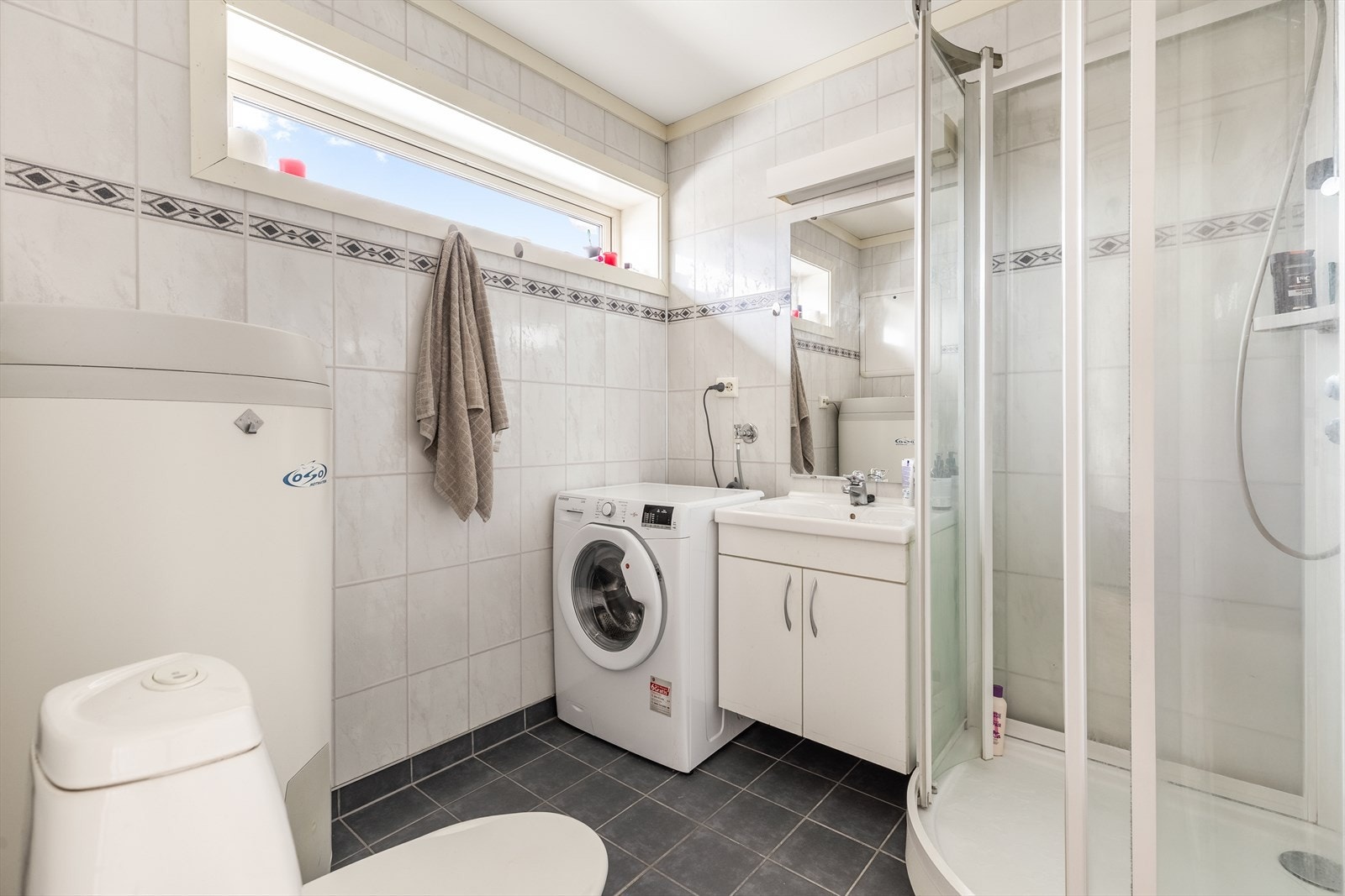 Flislagt bad med varmekabler og opplegg for vaskemaskin Galleribilde