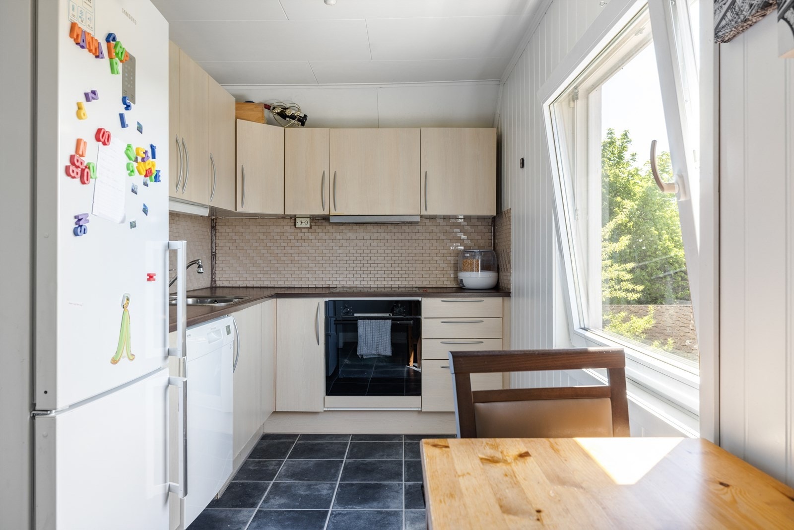 Koselig kjøkken med plass til kjøkkenbord ved vindu. Galleribilde