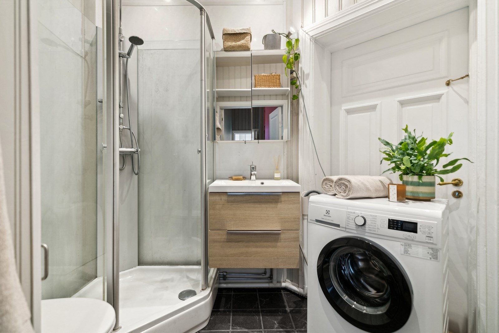 Badet er utstyrt med dusjkabinett, wc, vegghengt servant og vaskemaskin. Galleribilde