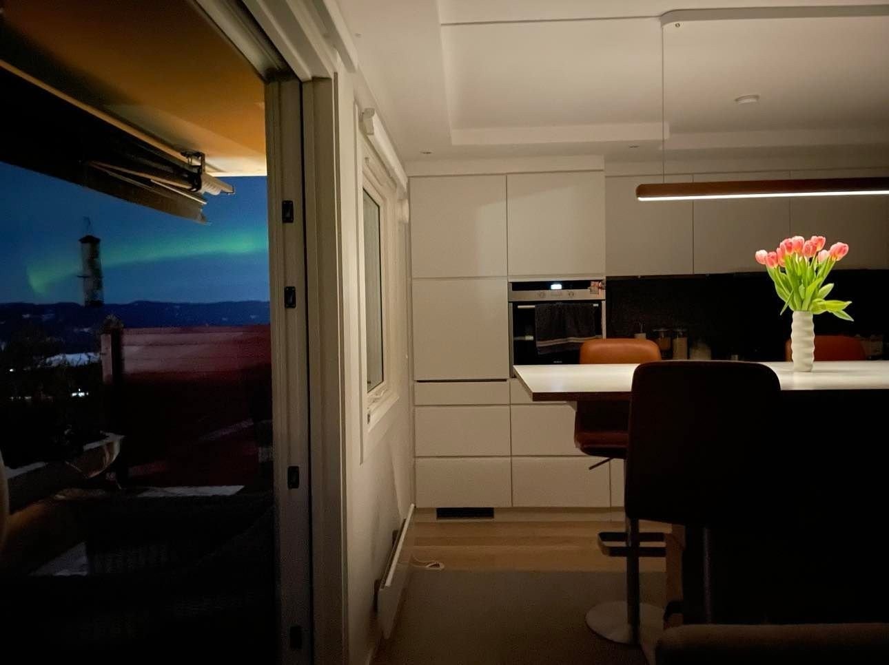 Å observere nordlys fra stuen eller terrassen mens man drikker varm kakao er en fin vinteraktivitet. Nordlysbildet ble tatt i februar 2022. Uretusjert bilde. Galleribilde