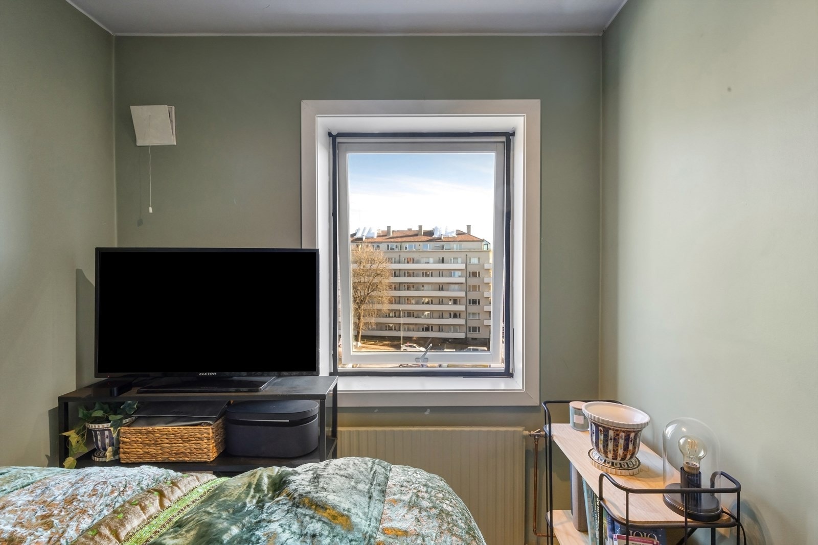 Med skyvedør mot stuen og radiator tilkoblet fjernvarme, er soverommet både arealeffektivt og behagelig temperert. Galleribilde