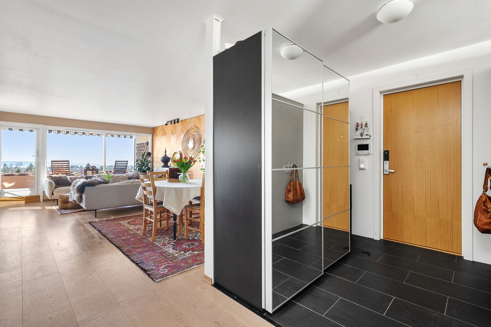 Flislagt entré med skyvedørsgarderobe for oppbevaring av yttertøy. Galleribilde