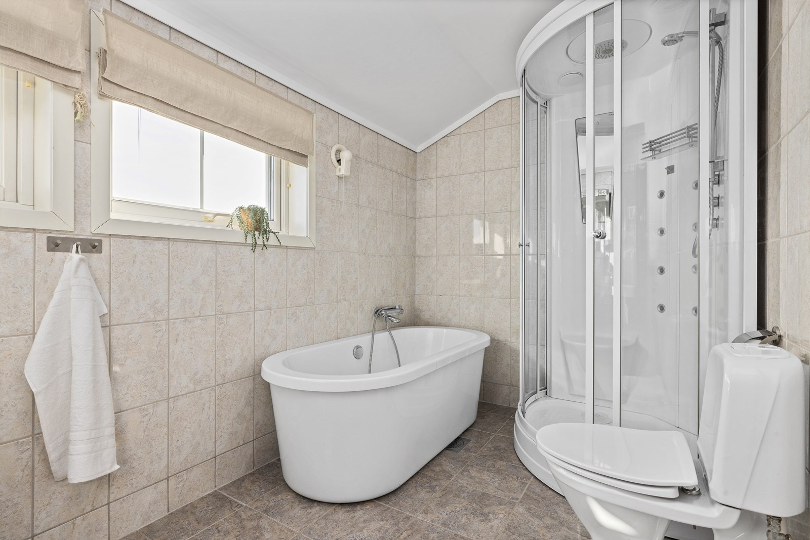 Baderommet er både utstyrt med dusjkabinett og badekar Galleribilde