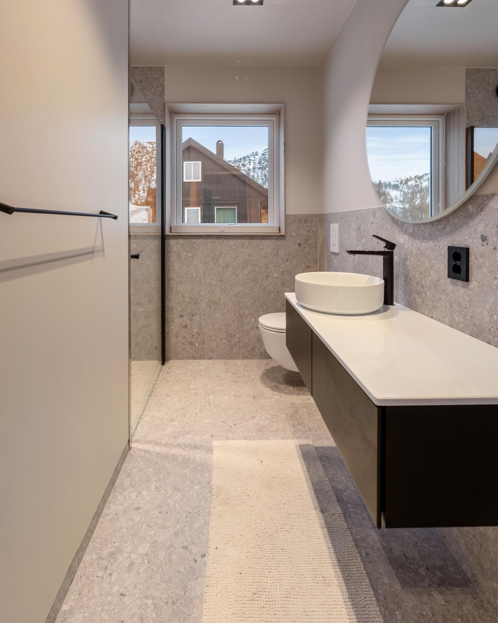 Bad med store fliser og dusjrom med glassdør Galleribilde