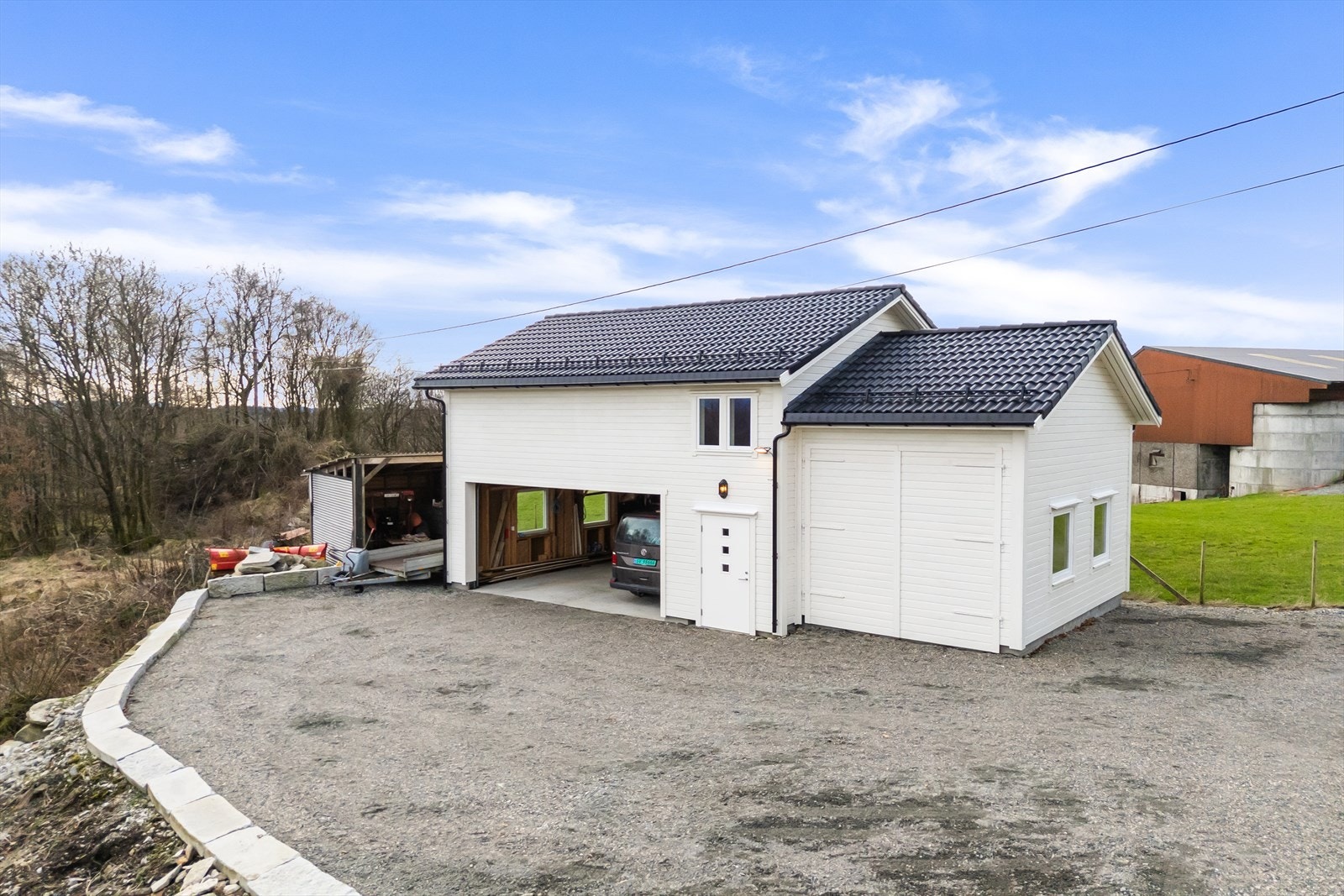 Tredobbel garasje med ekstra høy innkjøring i ene delen. Innredet garasjeloft. Galleribilde