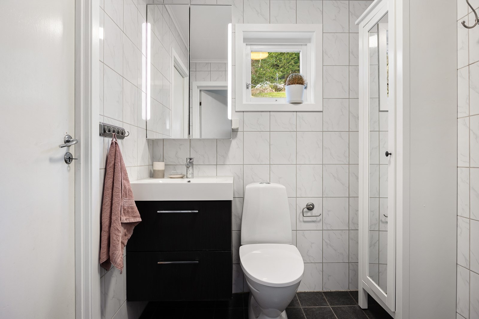 Baderommet er helfliset og innredet med dusj, toalett og servant med skap. Galleribilde