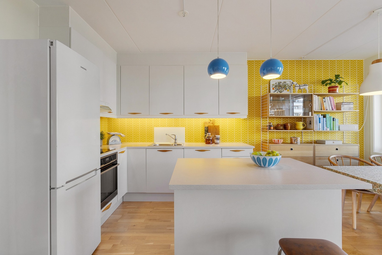 Moderne kjøkkenfronter og stilig tapetsert vegg over kjøkkenbenk Galleribilde