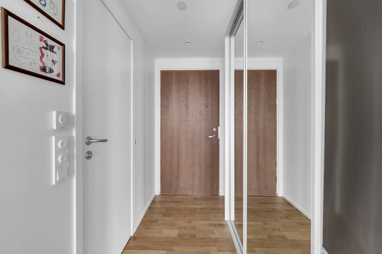 Innbydende entré med skyvedørsgarderobe og lys utforming. Galleribilde