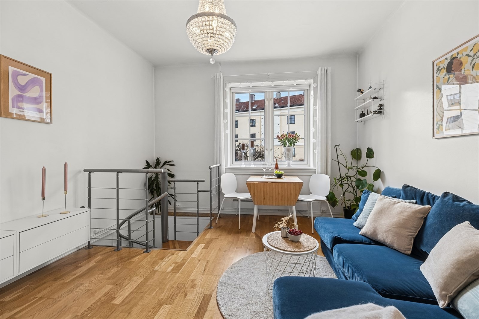 Det store, klassiske vinduet gir stuen et sofistikert preg og slipper inn rikelig med sollys, som skaper en lys og vennlig atmosfære. Galleribilde