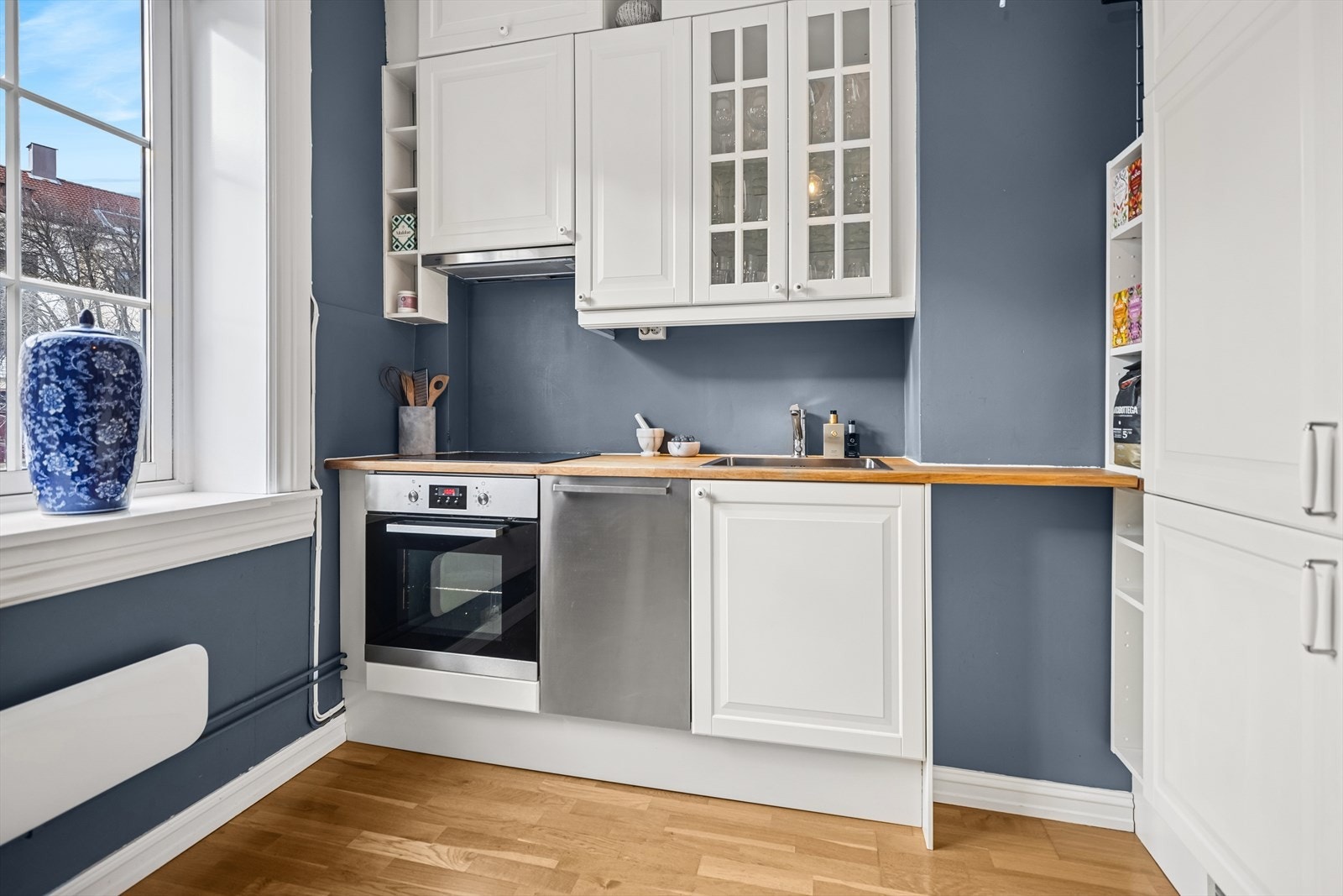 Leiligheten byr på et lyst og innbydende kjøkken med store, klassiske vinduer. Galleribilde