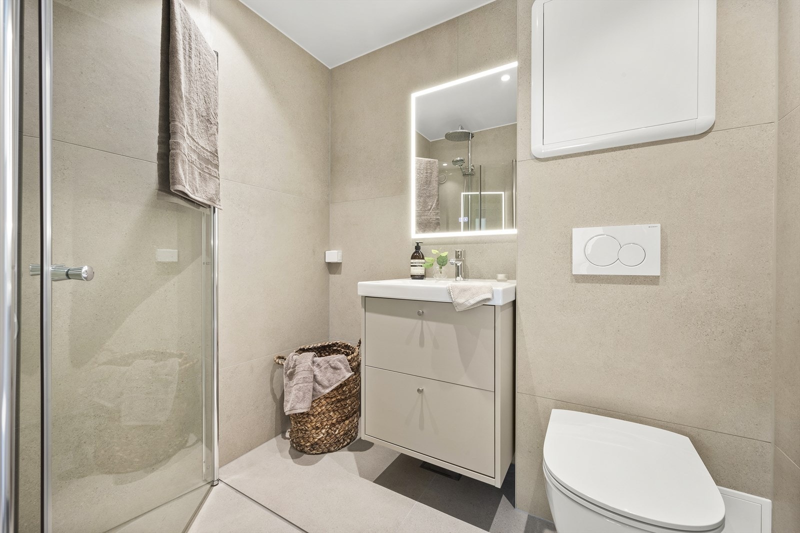 Lekkert nyoppusset baderom fra 2025 med beige fliser på gulv og vegger som gir en god romfølelse. Galleribilde