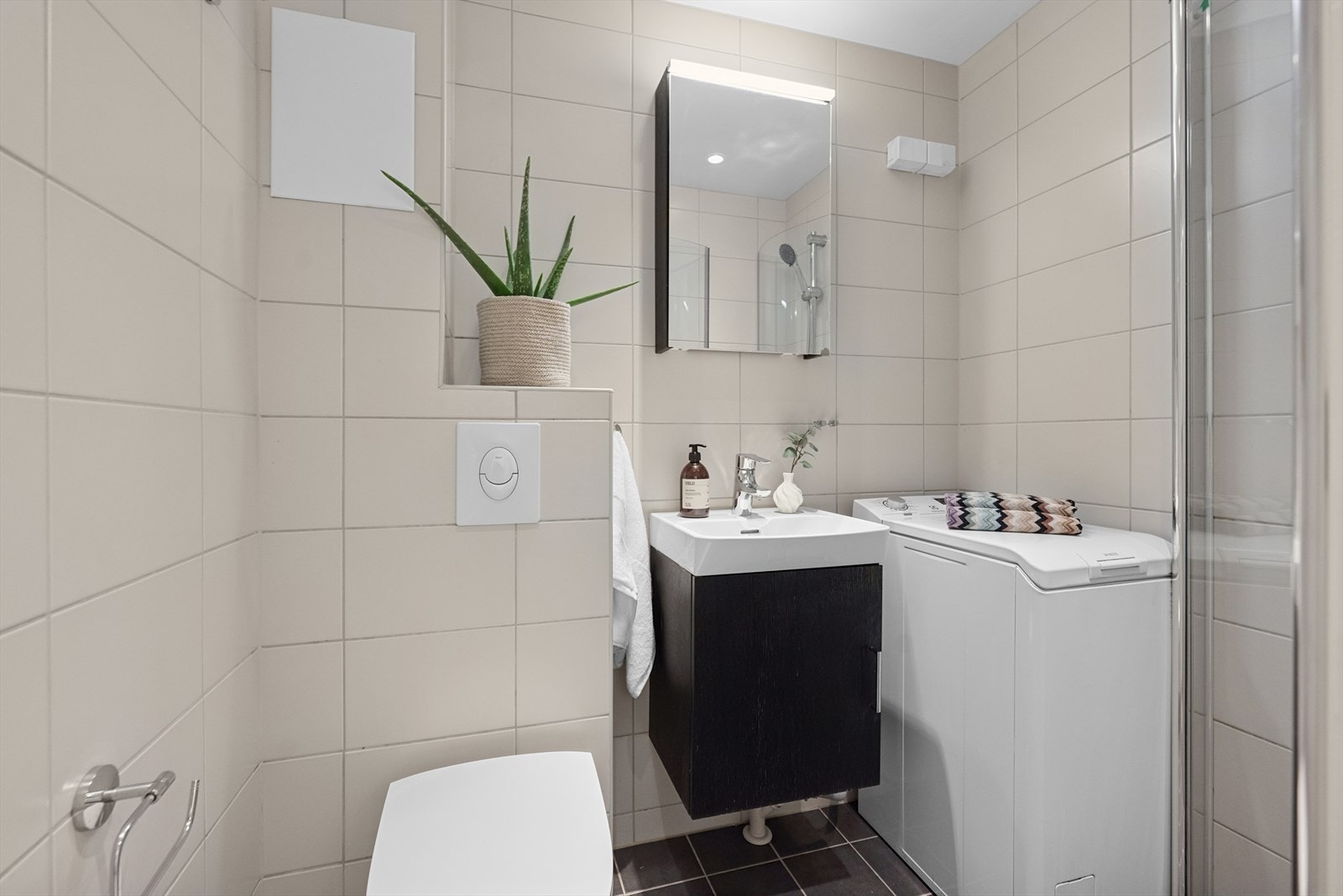 Her er det dusjhjørne, vegghengt toalett, servant med skapseksjon, samt opplegg for vaskemaskin. Galleribilde