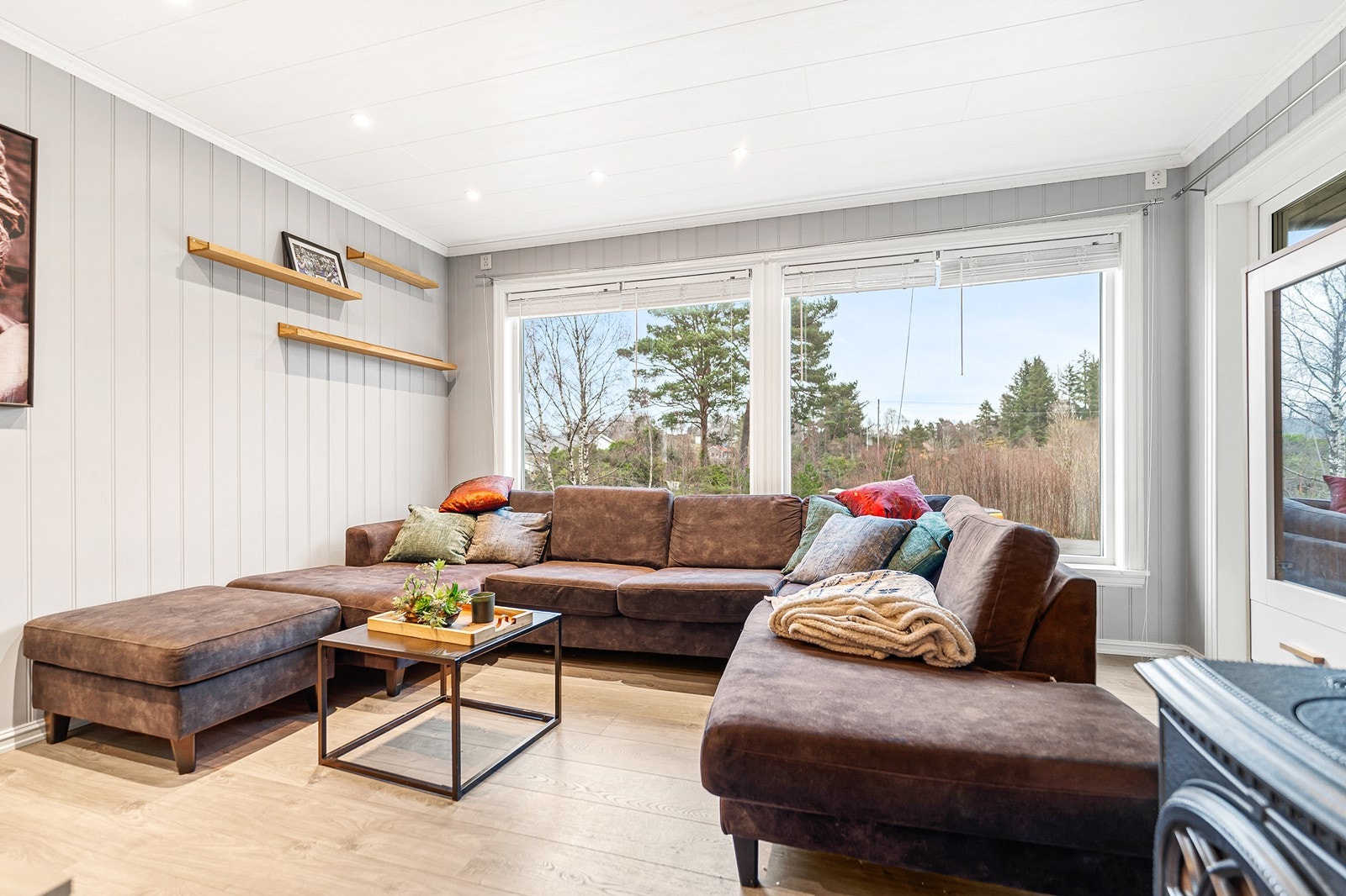 Store vindusflater gir godt med naturlig lysinnslipp i rommet og noe utsikt fra stuen. Galleribilde