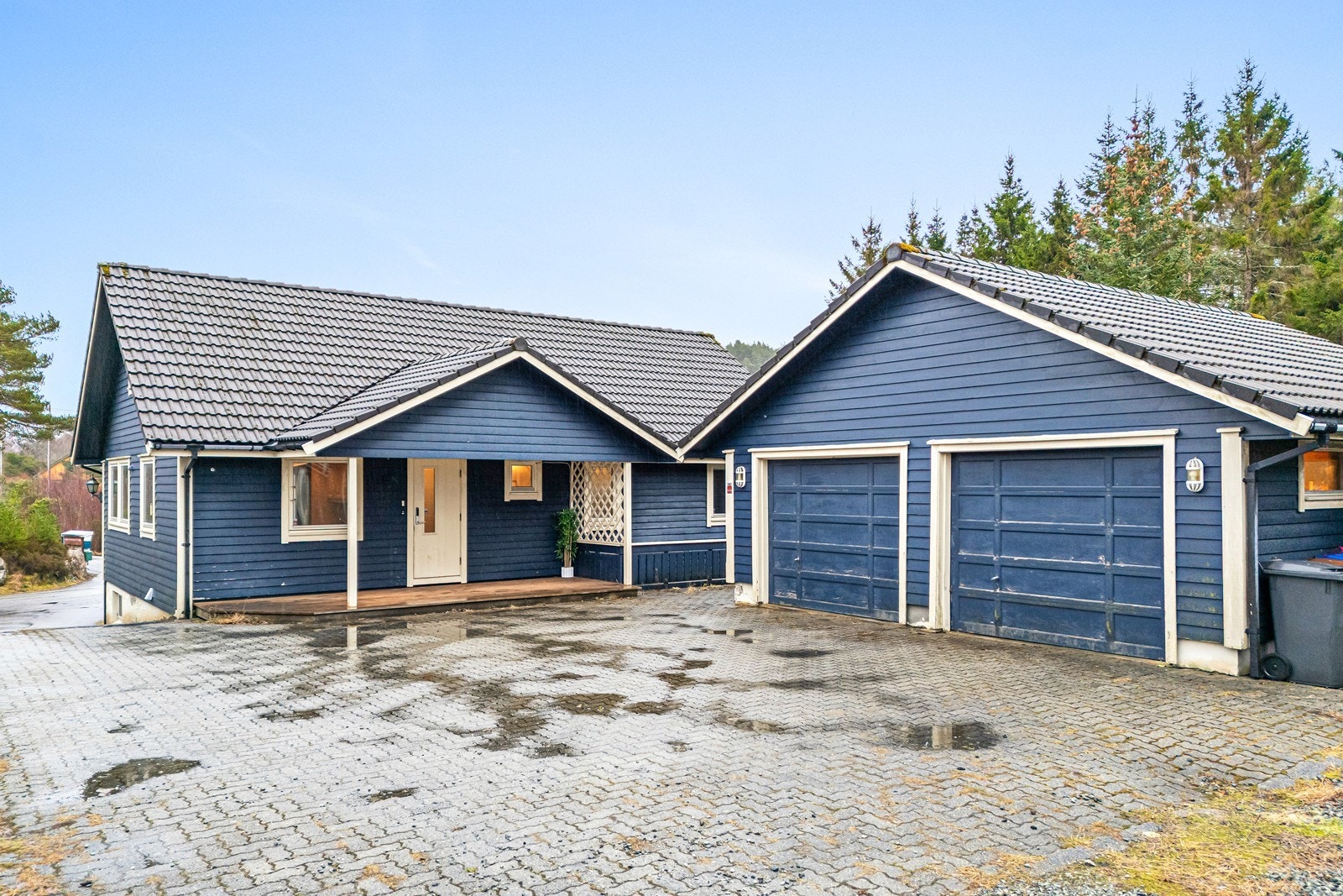 Tomten har asfaltert innkjørsel og brostein og gruset tun. Galleribilde