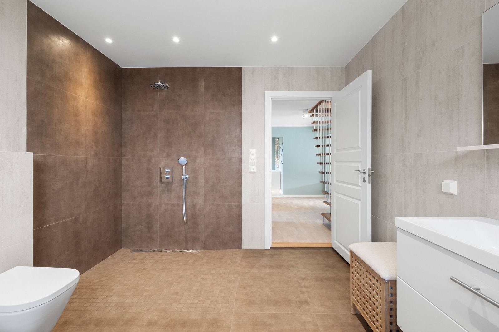 Dusjhjørnet har slukrenne, regnfallsdusj og mosaikkfliser. Galleribilde