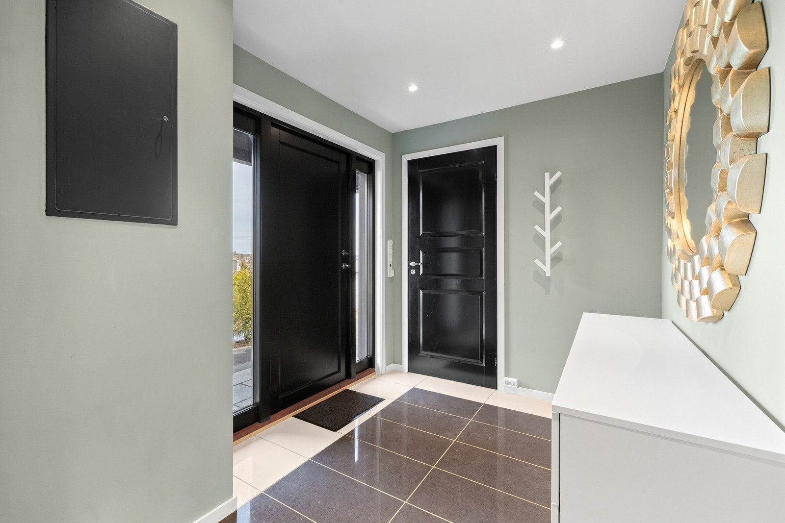 Entreen gir et fint førsteinntrykk, med downlights, grønne vegger og store gulvfliser i ulike grånyanser. Galleribilde