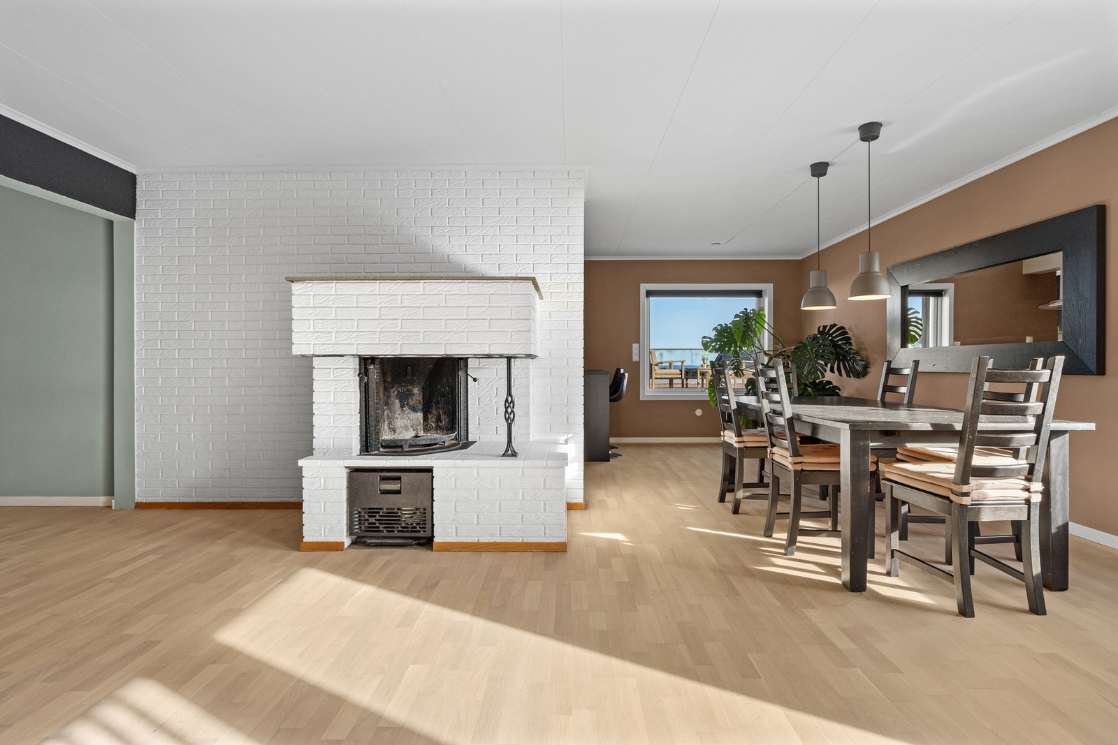 Med både peis og varmepumpe får man det lunt og godt, og dagslyset i stuen suppleres godt av downlights langs det ene vinduet. Galleribilde