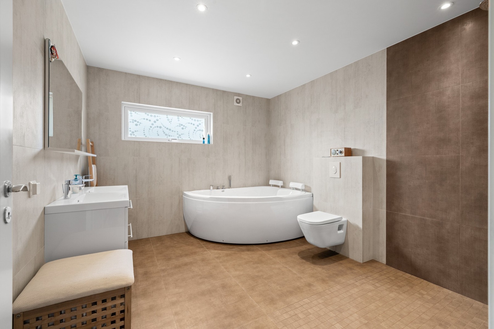 Hovedbadet er stort og delikat med deilig spa-atmosfære. Badet har dusjhjørne og et stort hjørnebadekar med dusjløsning. Galleribilde