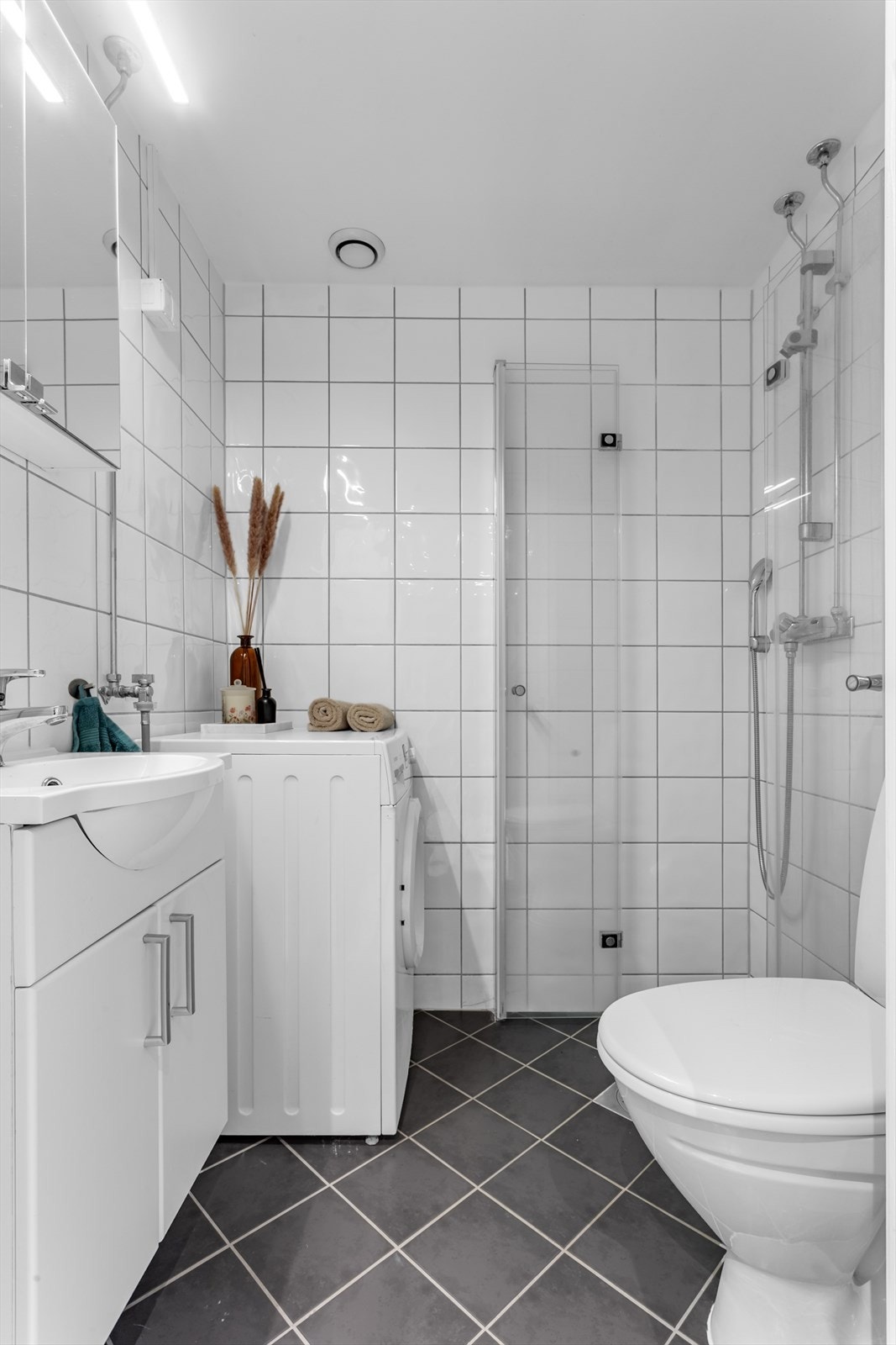 Pent flislagt bad med varmekabel som er pusset opp i regi av borettslaget i 2010. Badet har dusj med leddede glassvegger i herdet glass, innredning med servant og underskap, speilskap, toalett, samt opplegg for vaskemaskin. Galleribilde