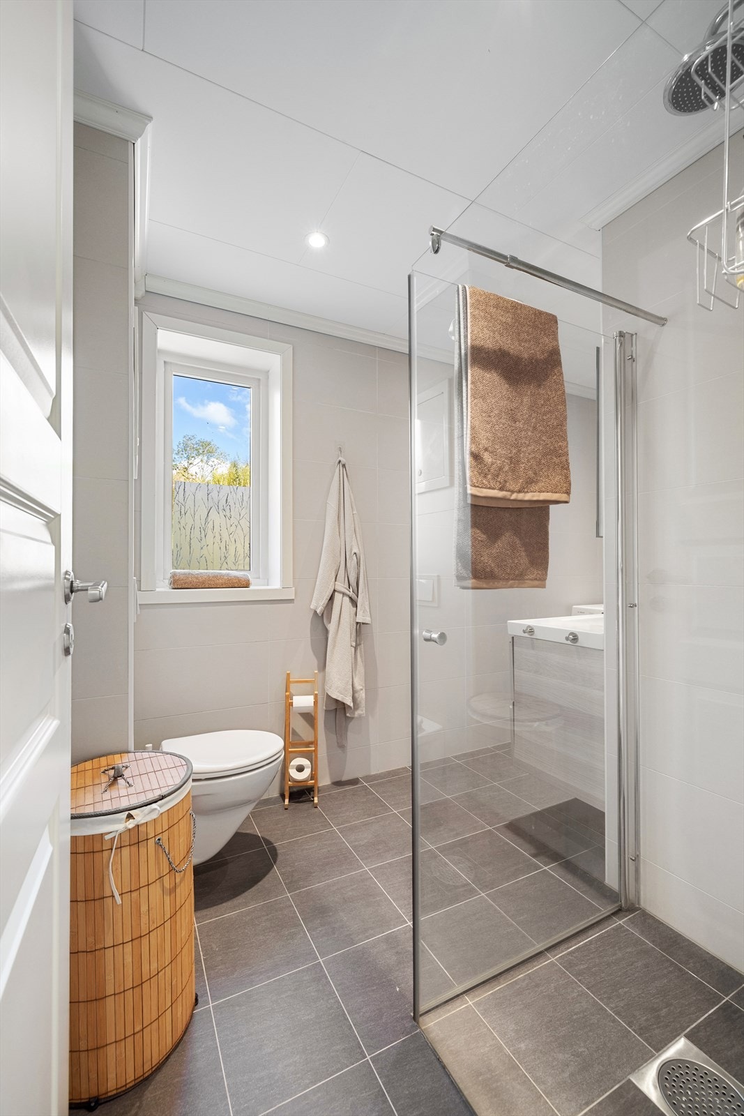 Pent bad med store fine fliser og praktiske løsninger. Galleribilde