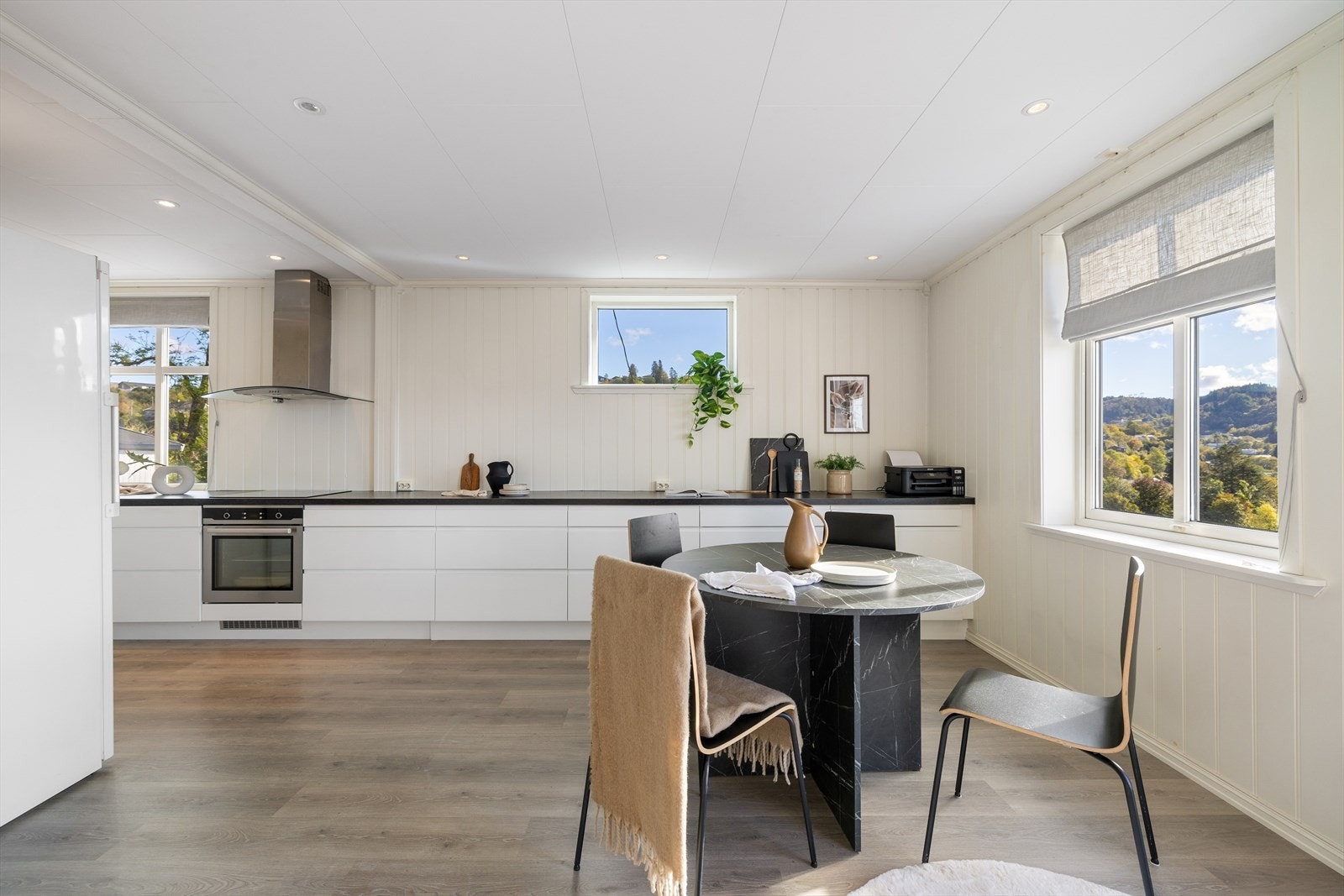 Kjøkkenet har en avlang og praktisk løsning. Den mørke benkeplaten krydrer kjøkkenet med en stilfull kontrast. Galleribilde