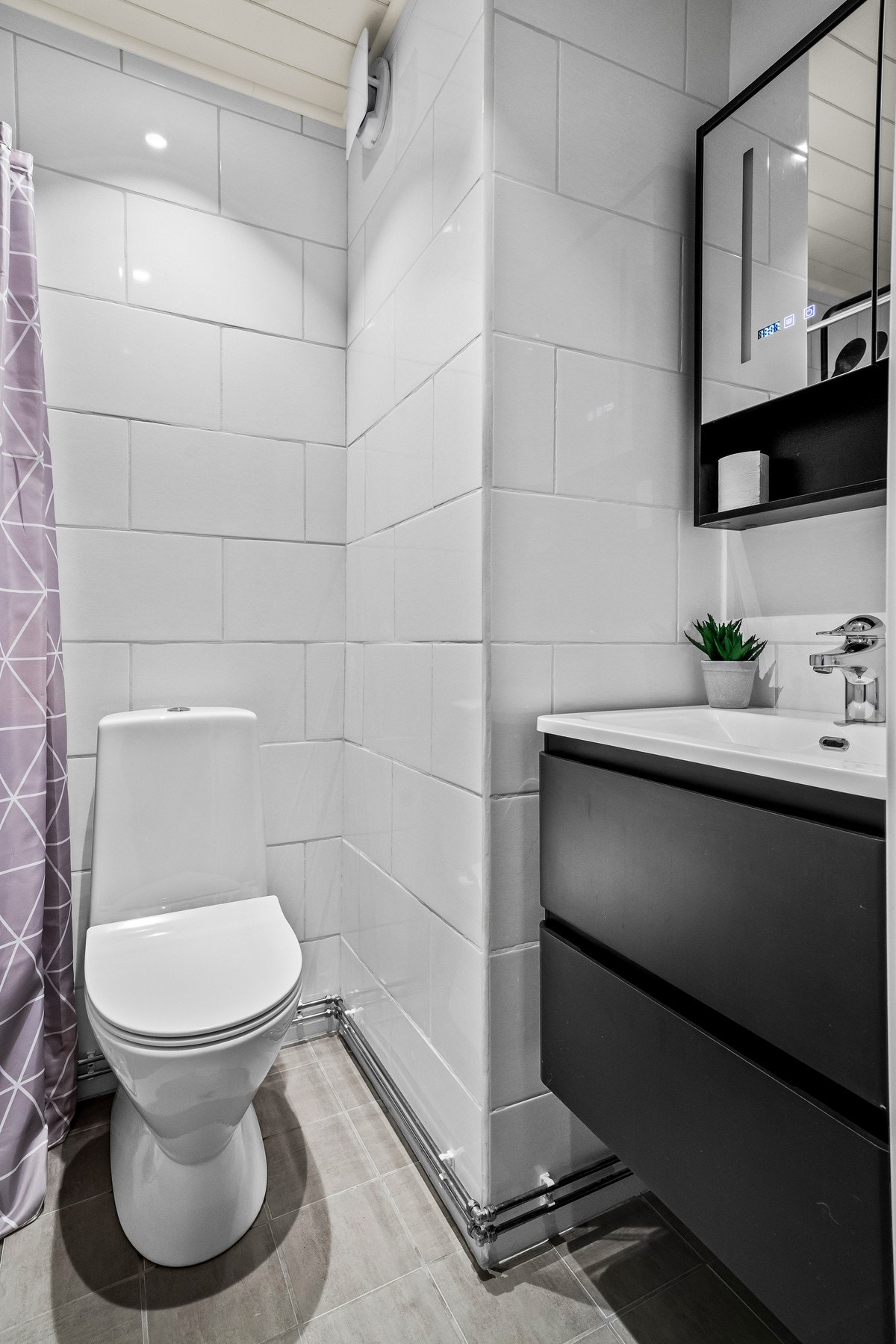 Svarte detaljer på servantskap, speil og dusj. Galleribilde