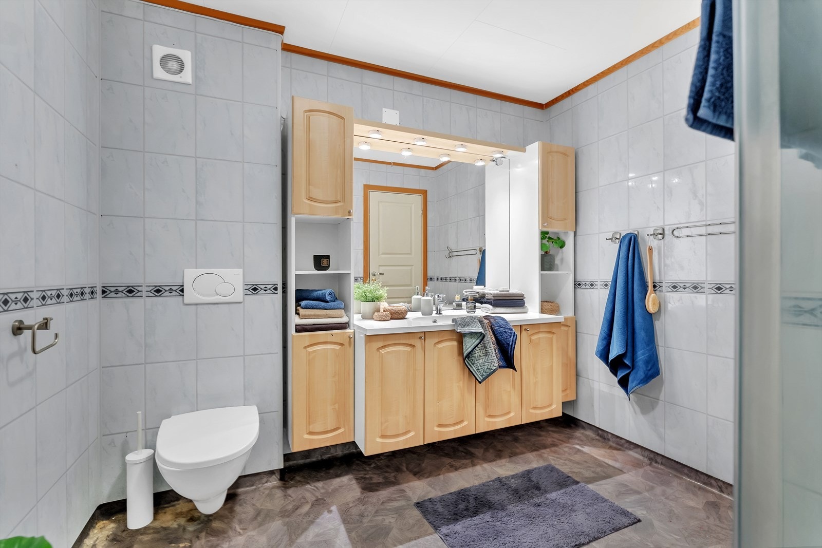 Bad med gulvbelegg, flislagte vegger og innredning med god skapplass. Galleribilde