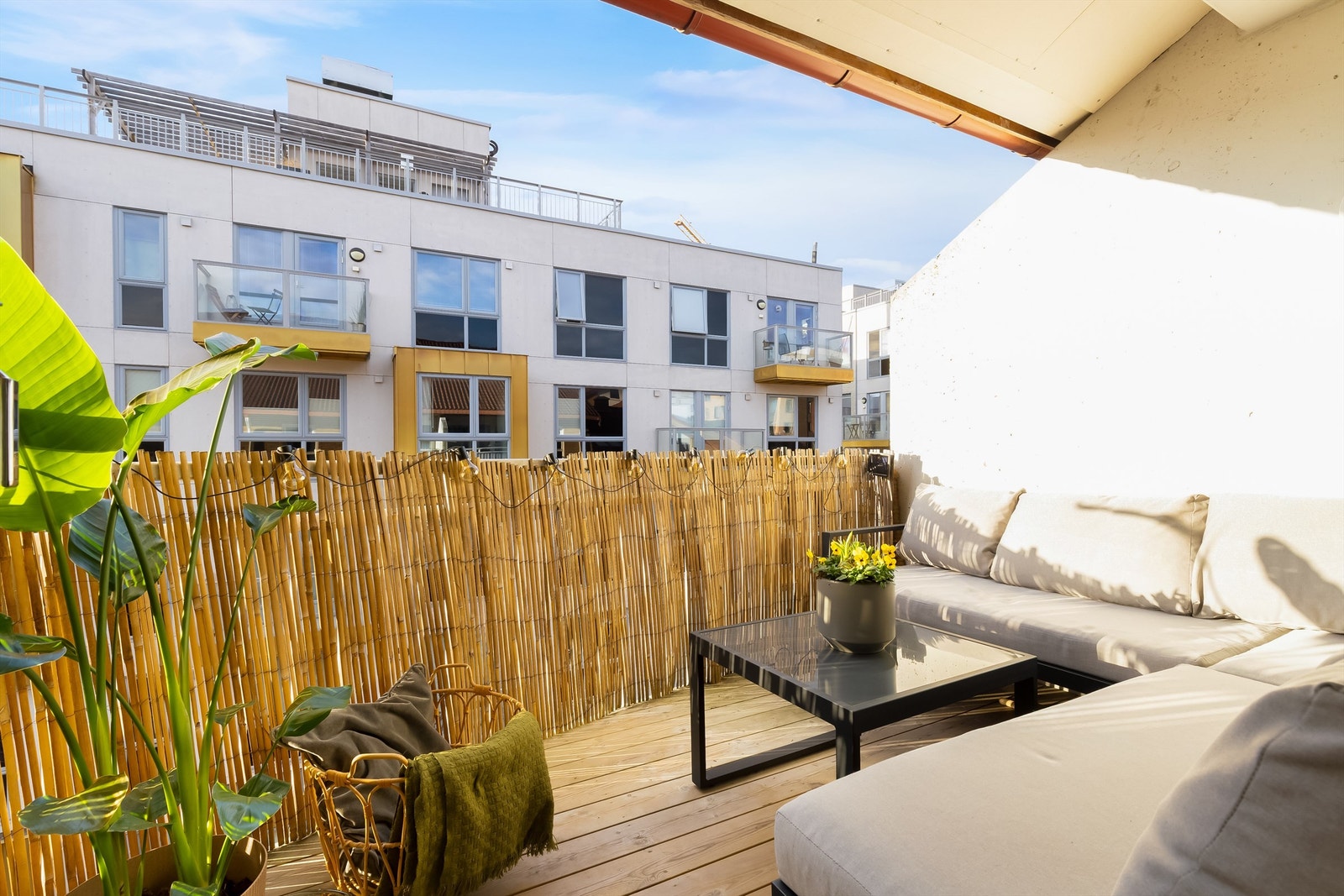 Balkongen er delvis inntrukket og har terrassebord på gulvet. Galleribilde