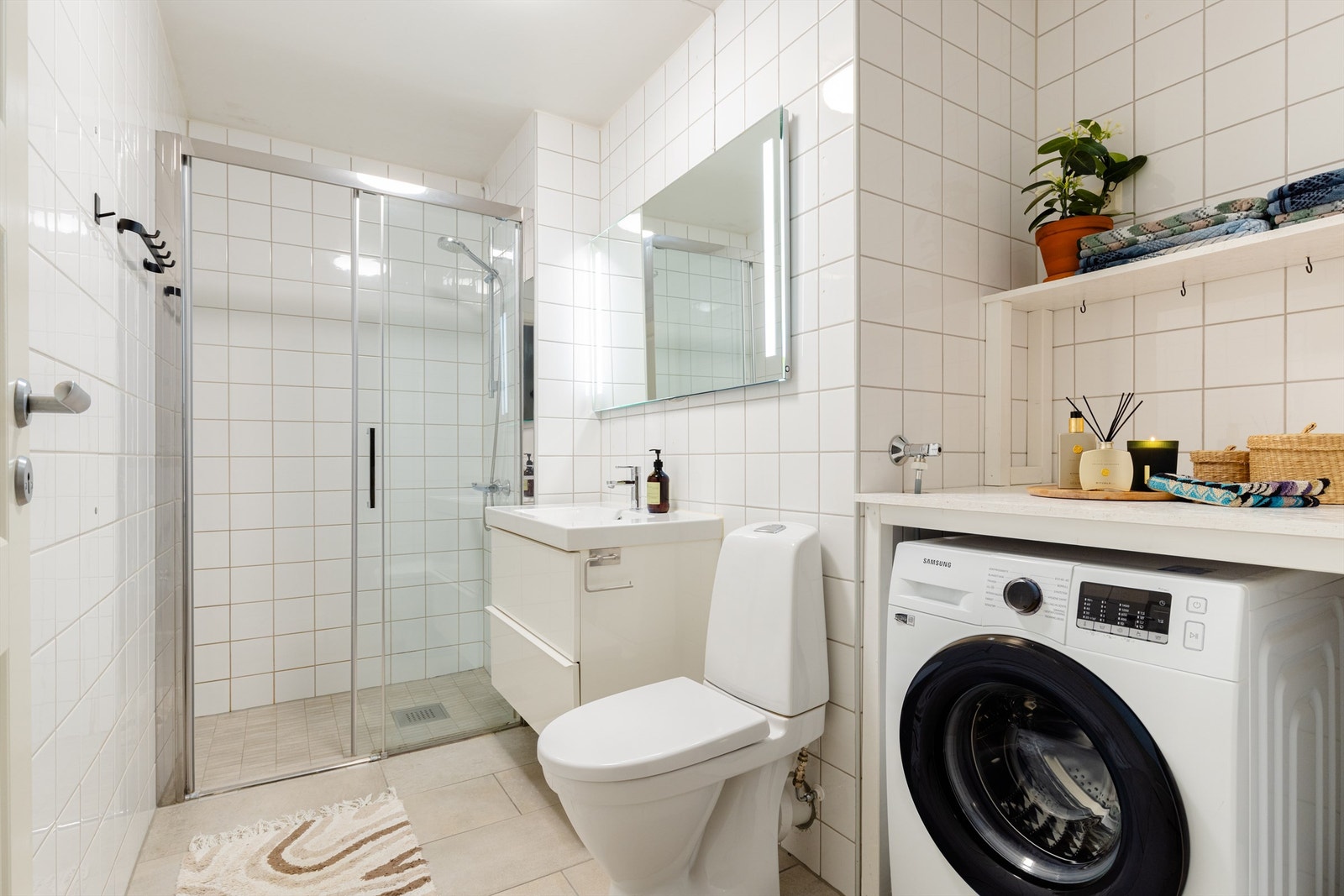 Lyst og romslig bad med gulvvarme. Badet er fra byggeår, men ble i 2019 overflateoppusset av tidligere eier. Det ble ikke gjort noe med baderomskonstruksjonen (sluk, membran m.m.), men det ble lagt nye fliser på eksisterende gulvfliser og ny innredning. Galleribilde