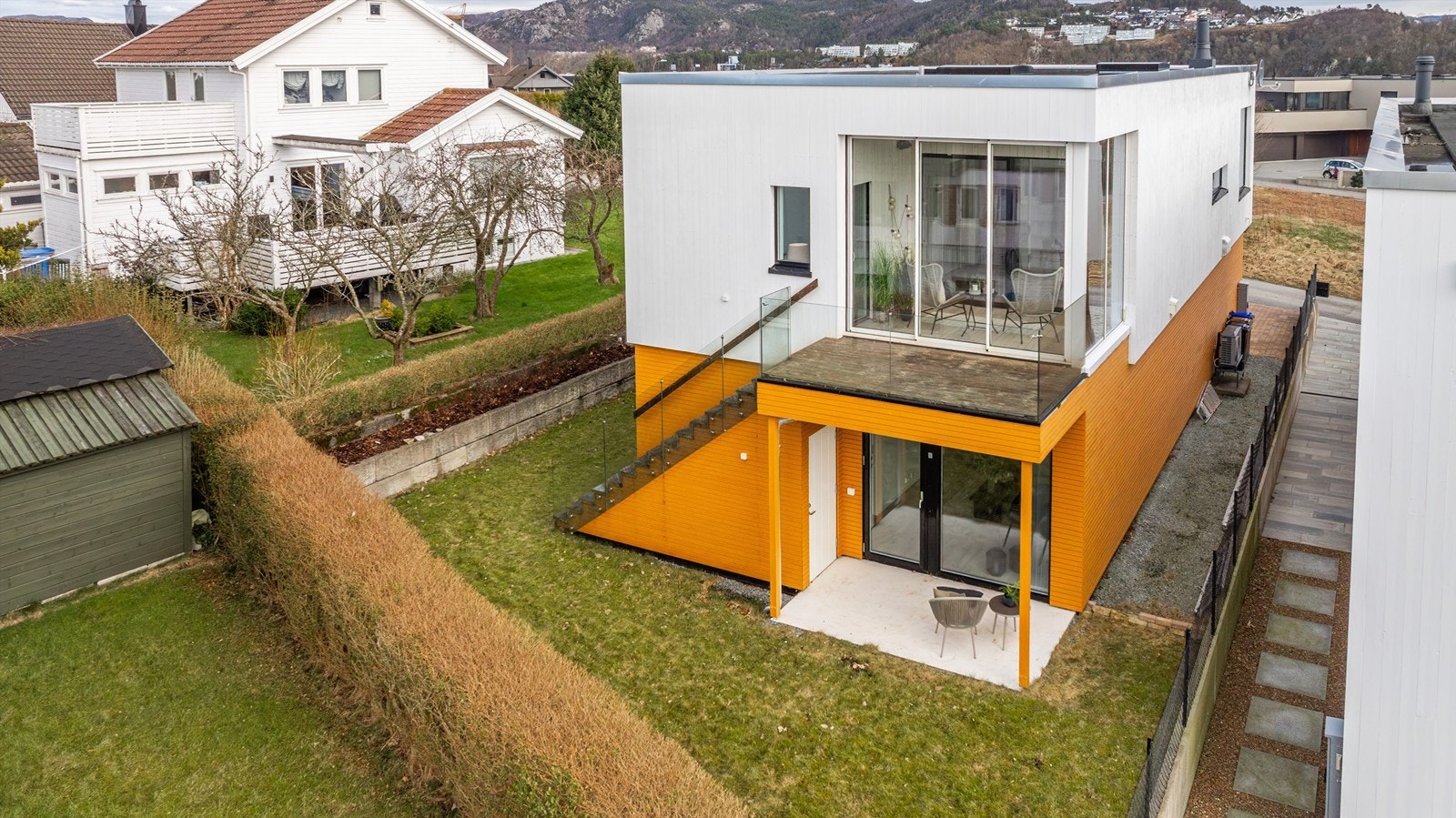 Det er fin opparbeidet tomt med belegningsstein, gressplen som strekker seg rundt store deler av boligen og terrasse utenfor kontor og vinterhage i 2.etg. Galleribilde
