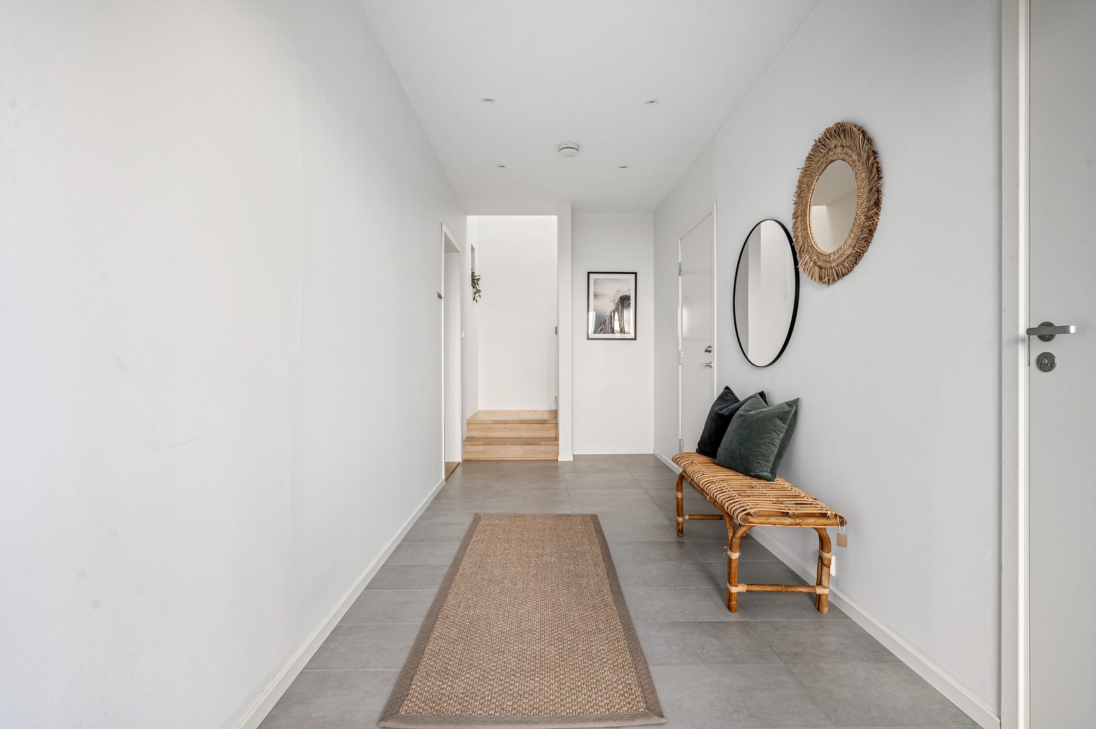 Inn inngangsdøren kommer man til en meget romslig og åpen entré med fliser på gulv, varme i gulv og god oppbevaringsplass til yttertøy. Det er spotter i tak og lyse veggflater. Galleribilde