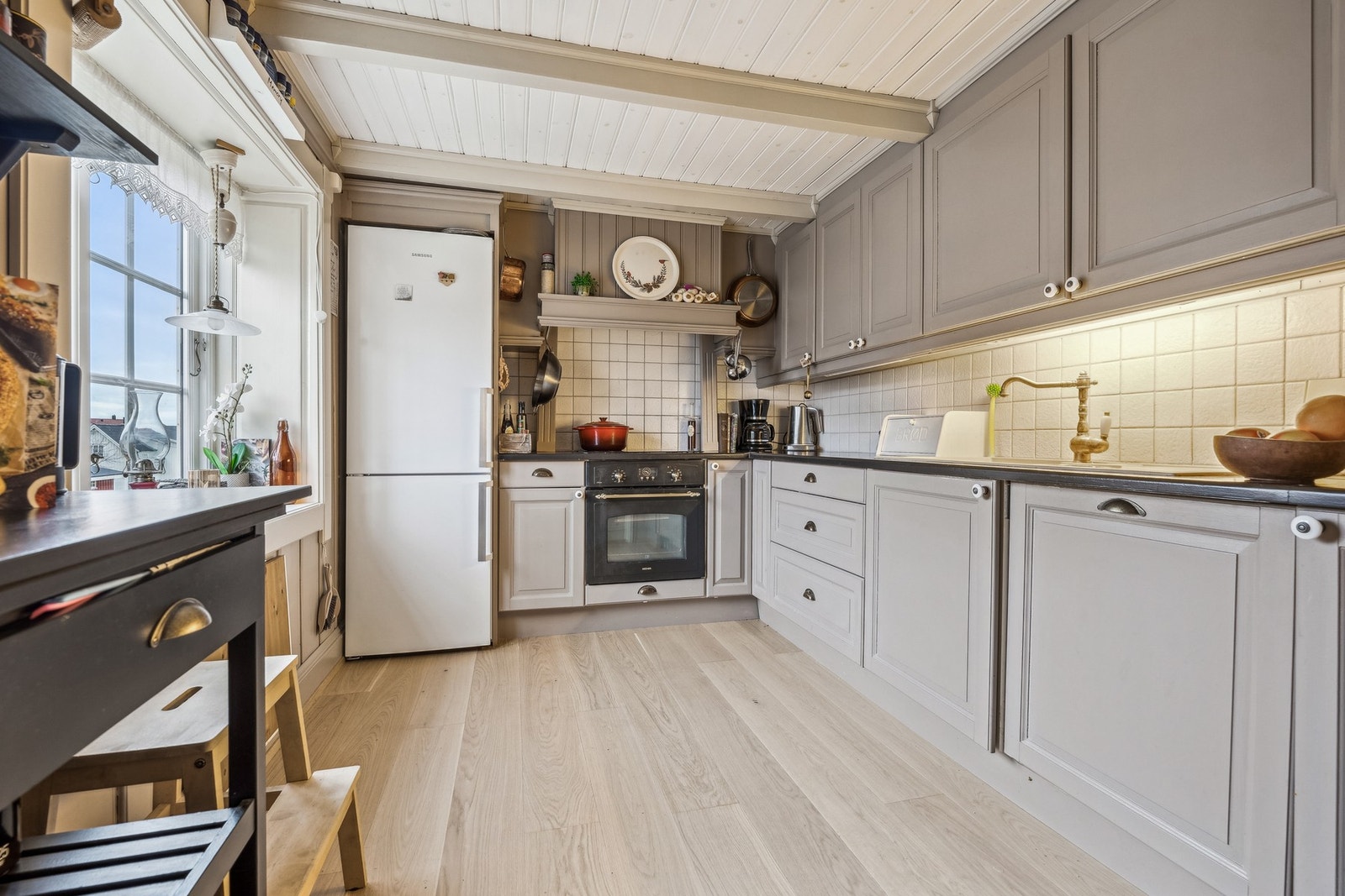 Kjøkkeninnredningen har malte, profilerte fronter og
benkeplate i heltre og flu Galleribilde