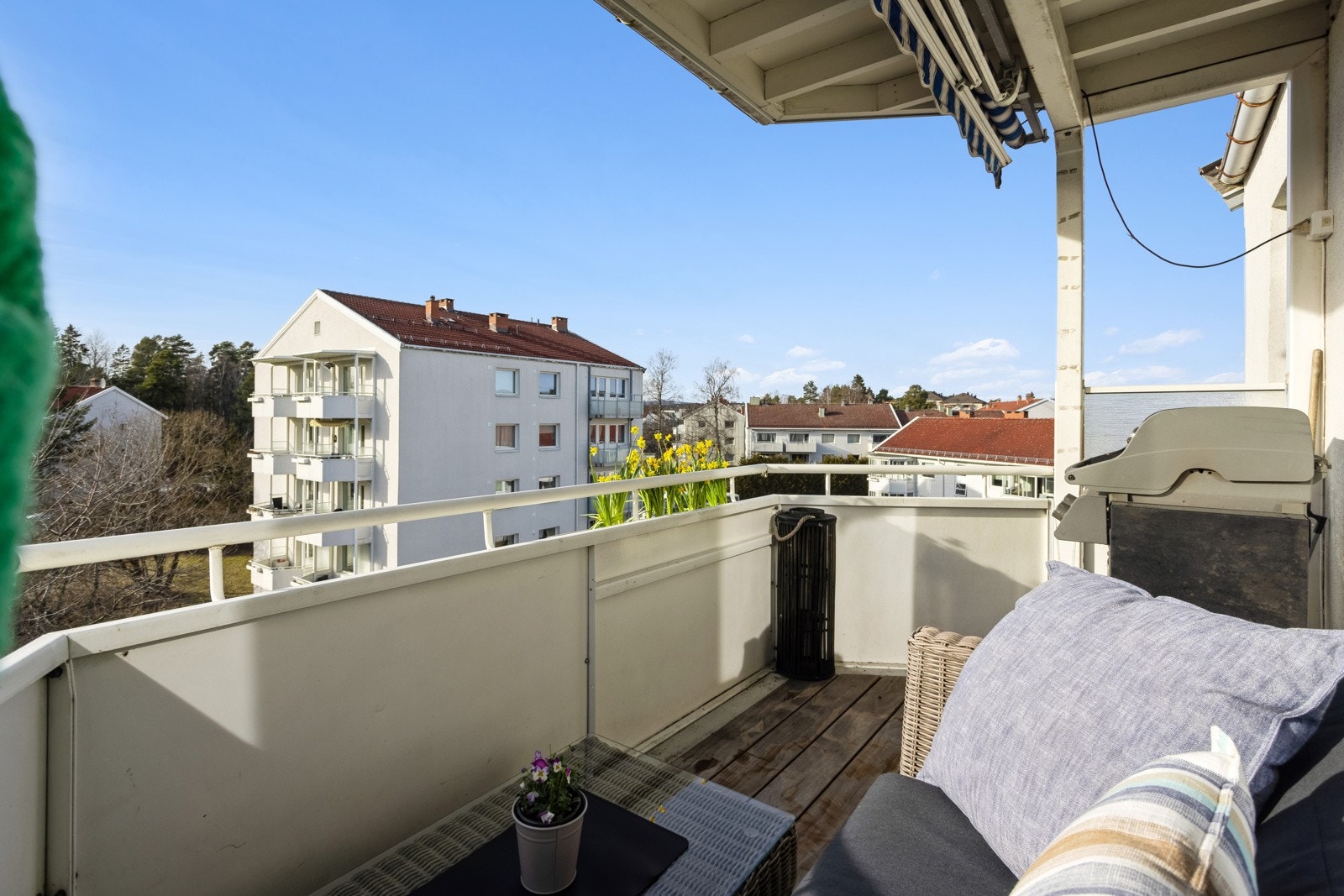 Balkongen har terrassebord på gulv, stikkontakt på vegg og markise. Galleribilde