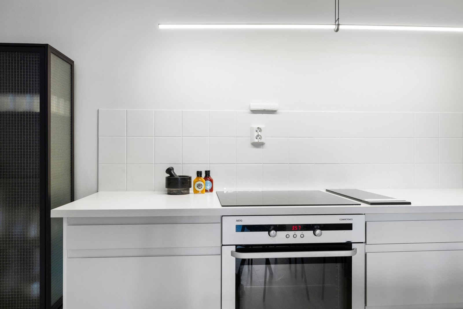 Kjøkkenet innehar benkeplate i laminat med nedfelt kum, malte fliser og lys over benkeplate på en side. Nedtrekkbar ventilator ved platetopp. Galleribilde