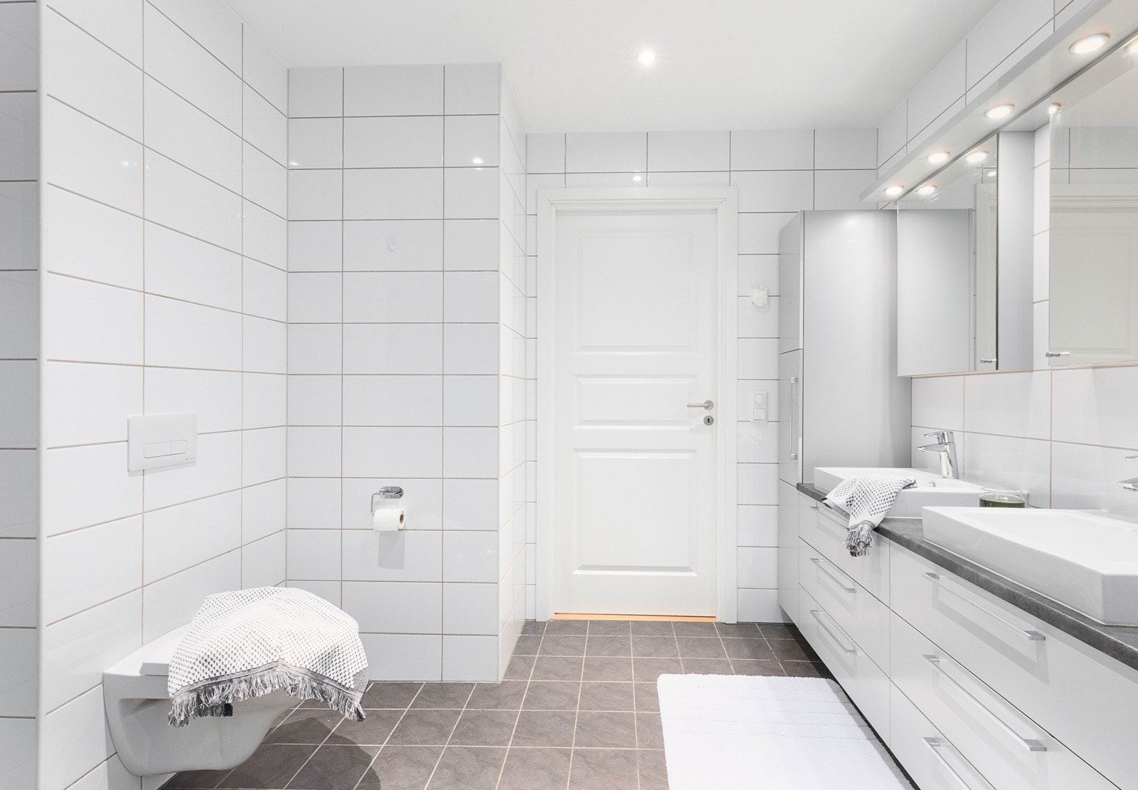 På badet er det dusjhjørne, baderomsinnredning med oppbevaringsmuligheter, toalett og opplegg for vaskemaskin Galleribilde