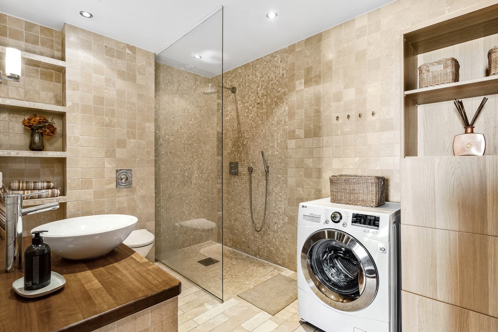 Badet er utstyrt med servant, veggmontert toalett og dusjvegger/hjørne. Det er plass og opplegg for vaskemaskin. Baderommet har naturlig ventilering. Galleribilde