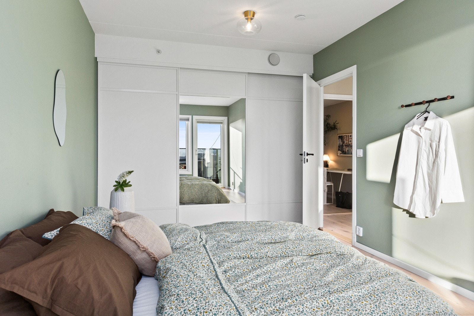 Det er gode oppbevaringsmuligheter i en takhøy skyvedørsgarderobe. Galleribilde